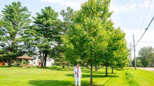 Jane Brown in Waterbury standing next to a tree planted through a UCF grant